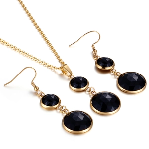 Elegant jewelry set with necklace and earrings featuring black gems in gold finish