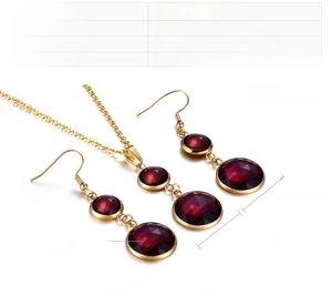 Detail view showing wine red crystal pendant and hook earrings with precise dimensions