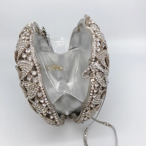 Close-up of silver rhinestone evening clutch bag with chain strap and shiny metallic frame