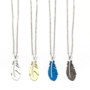 Detail view of angel feather pendants in silver, gold, blue and black stainless steel