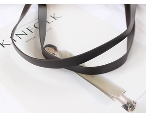 Close-up of premium dark brown leather shoulder strap with fine texture on Kinfolk magazine