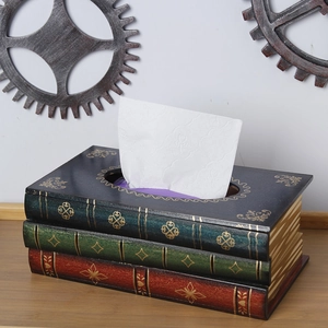 Close-up of vintage stacked books tissue box with golden patterns and faux wood grain