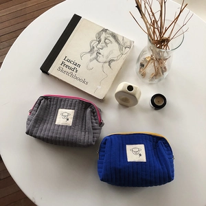 Dettaglio di pochette trapuntate con toppe a forma di pecora su una scrivania in stile