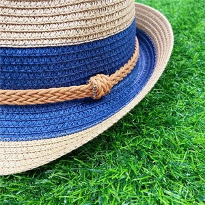 Macro detail of summer straw fedora hat featuring contrast weave and brown rope accent