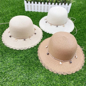 Chapeau de soleil en paille avec bord ondulé et décorations de perles et coquillages