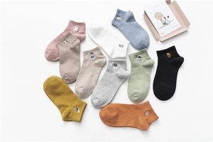 Close-up of ten pairs of cotton socks with diverse animal embroidery and ribbed cuffs
