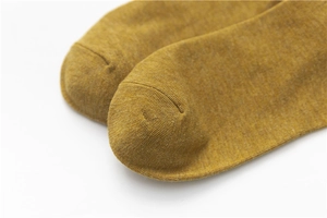 Detailed macro shot of yellow combed cotton sock toe with clean knitted texture