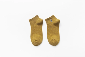 Close-up of ginger yellow cotton sock featuring a cute blue and white rabbit embroidery
