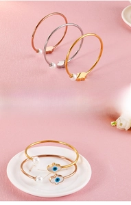 Bracelets ouverts Main de Fatma trois couleurs avec perles sur fond rose texturé