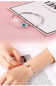 Détail du bracelet main de Fatma mauvais œil avec perle ronde sur un jonc doré ouvert