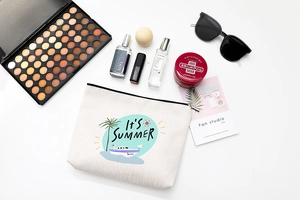 Vue à plat d'une trousse à maquillage en coton beige avec imprimé Summer et accessoires