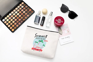 Vue à plat d'une trousse de maquillage en coton beige avec cosmétiques et accessoires