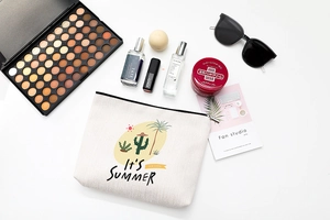 Mise à plat d'une trousse de maquillage en toile d'été avec imprimé cactus et accessoires