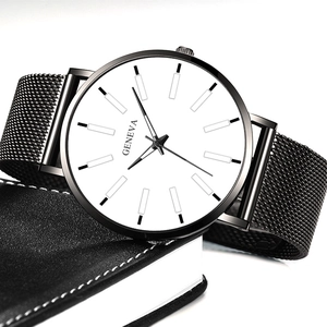 Reloj de cuarzo Geneva minimalista con correa de malla negra sobre una superficie de cuero