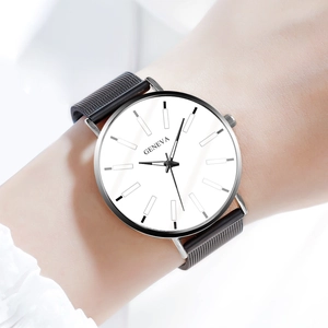 Primer plano de reloj Geneva con esfera blanca y correa de malla en la muñeca