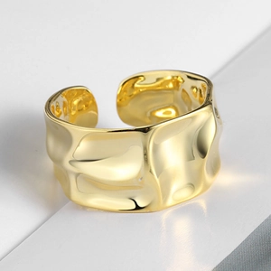 Detailed view of the gold irregular wavy texture on this wide minimalist metal ring