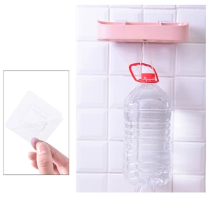 Detail of pink wall-mounted shelf with strong adhesive hook holding heavy water bottle