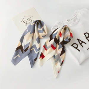 Flat lay of silk-feel scarves with geometric patterns and dots in assorted colors