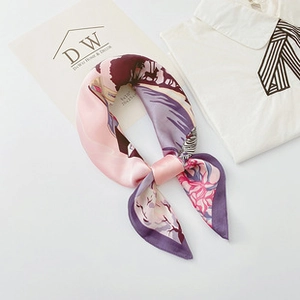 Detailed close-up of a satin silk-like square scarf with elegant floral prints