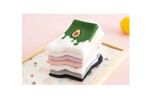 Detail of stacked colorful cotton socks featuring a cute green avocado pattern embroidery
