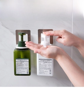 Macro detail of wall-mounted shampoo bottle holder with 400ml pump bottles in the bathroom