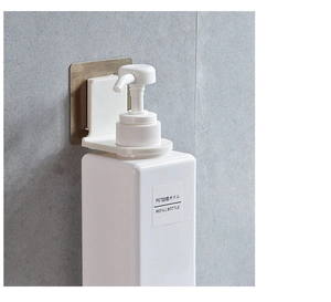 Detail showing wall-mounted shower gel holder and refill bottle on bathroom tiles