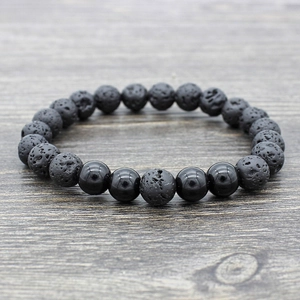 Black lava rock yoga beaded bracelet on dark wood background with polished accent beads