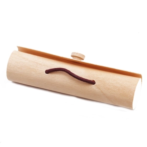 Detail view of cylindrical wooden gift box with elastic closure on white background