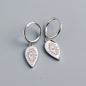 Macro shot of S925 sterling silver teardrop earrings with engraved totem and small diamond