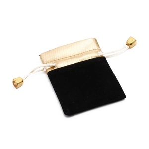 Detail of premium black velvet jewelry pouch with golden fabric and drawstring closure