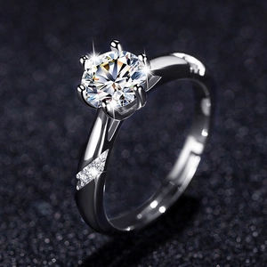Macro shot of six-prong solitaire ring with side diamonds and adjustable silver band