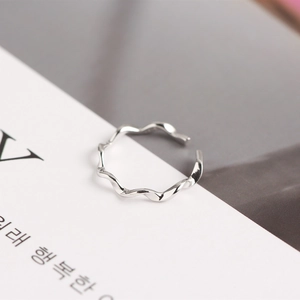 Macro shot of silver S925 Mobius twisted wave ring on a minimalist paper background