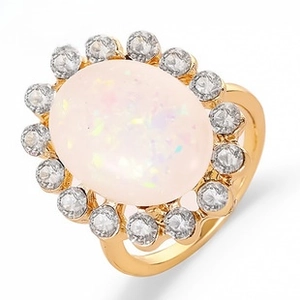 Macro detail of gold-plated twisted ring with halo-set oval opal and sparkling rhinestones