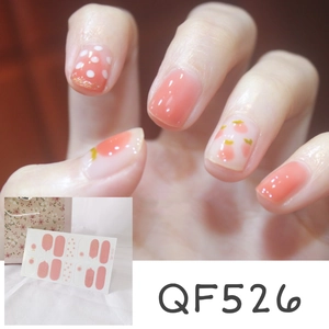 Close-up of peach and polka dot nail stickers showing gradient pink details