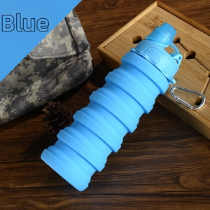 Close-up of blue collapsible silicone sports bottle with carabiner on wooden table