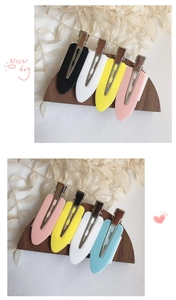 Detail view of colorful seamless hair clips in pastel tones on a natural wood display