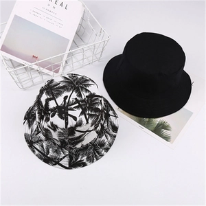 Detail showing solid black bucket hat alongside tropical palm tree print pattern