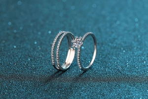 Macro shot of two S925 silver rings with round moissanite and pave diamond bands