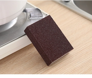 Close-up of a brown carborundum sponge on a wooden surface for kitchen rust removal