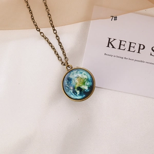 Detailed close-up of a vintage bronze earth pendant necklace on soft aesthetic background