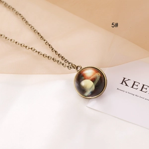 Macro shot of bronze vintage necklace with celestial Saturn dome glass pendant and mesh