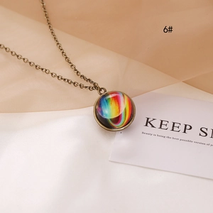 Luminous cosmic nebula glass pendant necklace with vintage bronze chain on a soft fabric
