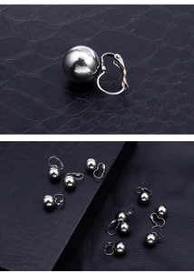 Close-up of polished stainless steel ball drop earrings with a mirror finish