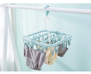 Close-up of 32-peg folding laundry rack in light blue plastic for socks and underwear