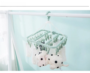 Close-up of windproof hook and durable clips on the green folding laundry drying rack