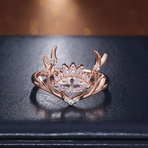 Dettaglio macro dell'anello corna di renna oro rosa con zircone marquise su pelle blu