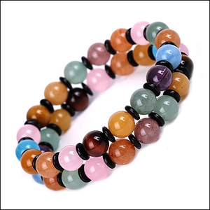 Macro shot of 8mm natural lava stone beads and colorful tiger eye gems on a yoga bracelet