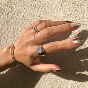 Close-up of stacked 925 silver rings with white agate gemstone on hands