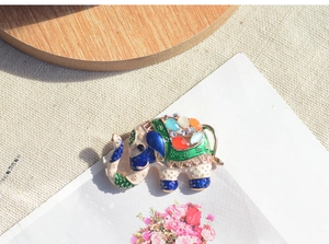 Gedetailleerde close-up van de emaille olifant broche met kleurrijke strasssteentjes.