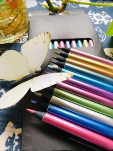 Macro detail of 12 metallic colored pencils showing vibrant tips and smooth black wood